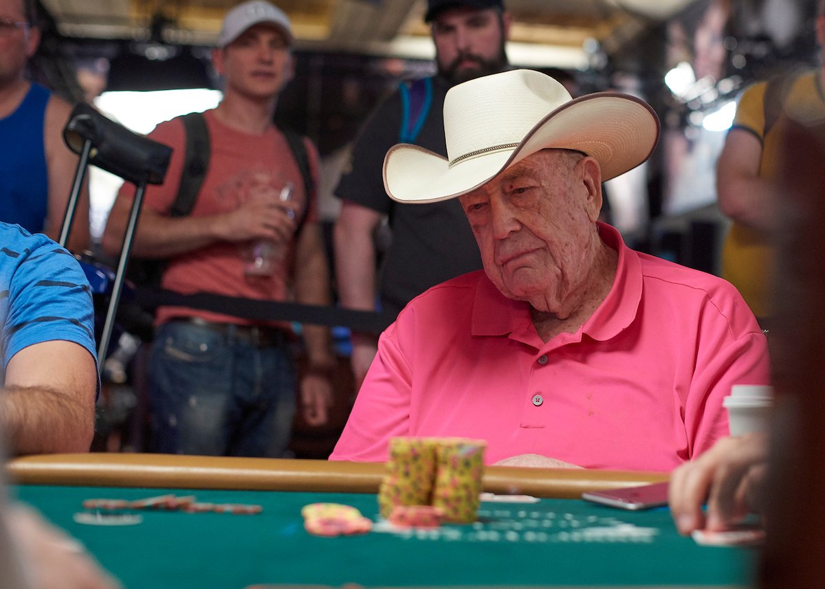 Doyle Brunson playing poker wearing a hat and a pink shirt